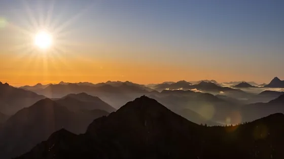 After: warm sunrise over layered mountains — preview of the One-line Reframe micro-test.