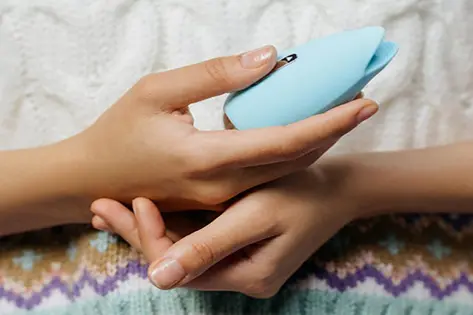 Minimal intimate moment with a soft blue vibrator