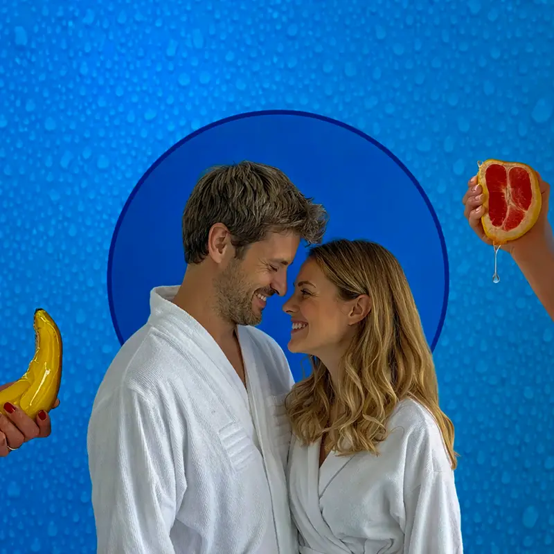 Couple in soft white robes sharing a gentle, intimate moment, symbolizing comfort, hydration, and body-safe intimacy.